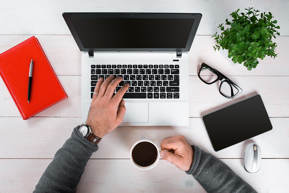 A man typing on a laptop while browsing matched betting tips.