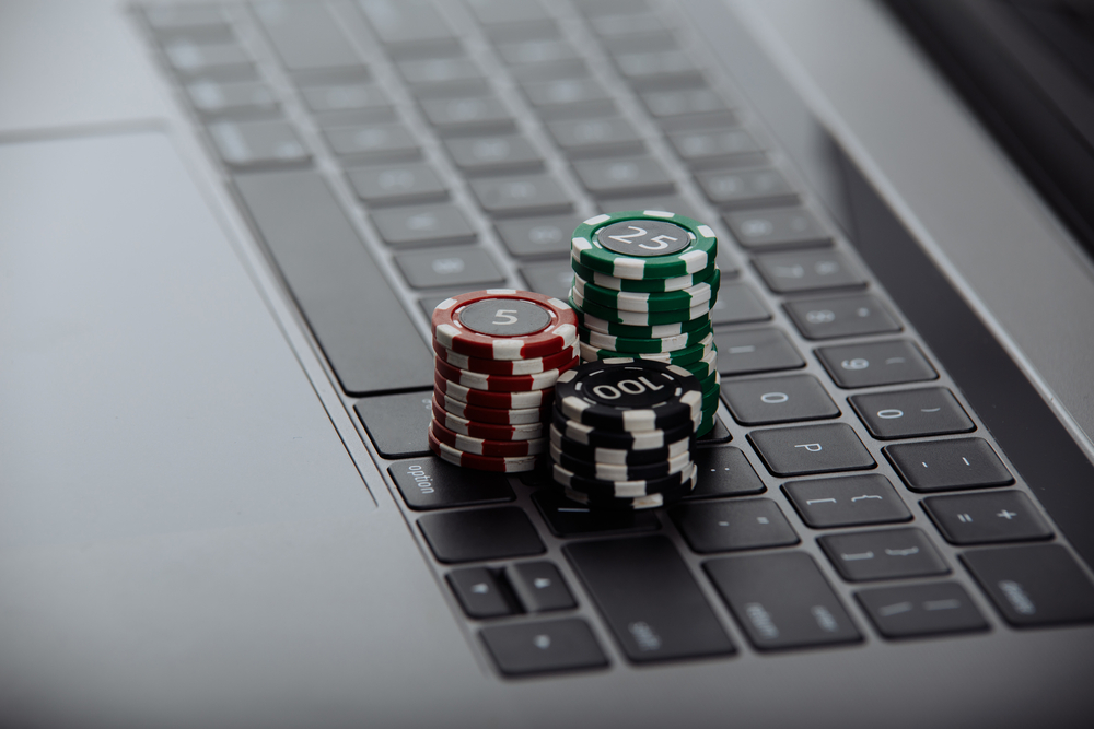 Close up shot of Poker chips sitting on laptop keyboard. Online casino games are a big part of matched betting.