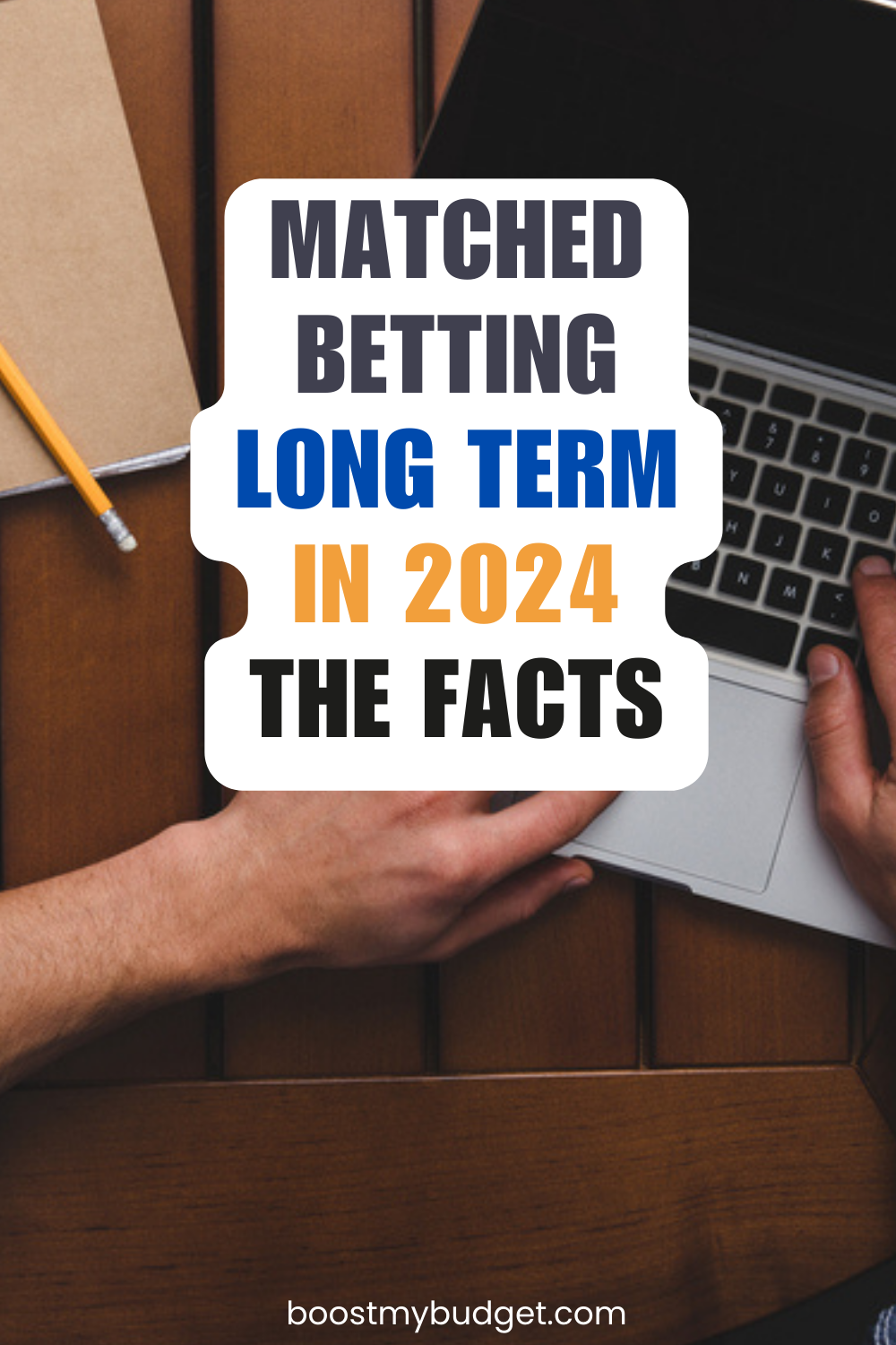 Close-up of hands typing on a laptop keyboard with text reading "Matched Betting Long Term in 2024: The Facts" overlaid. A pencil, paper, and wooden table are also visible.