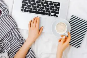 woman working in bed on her laptop