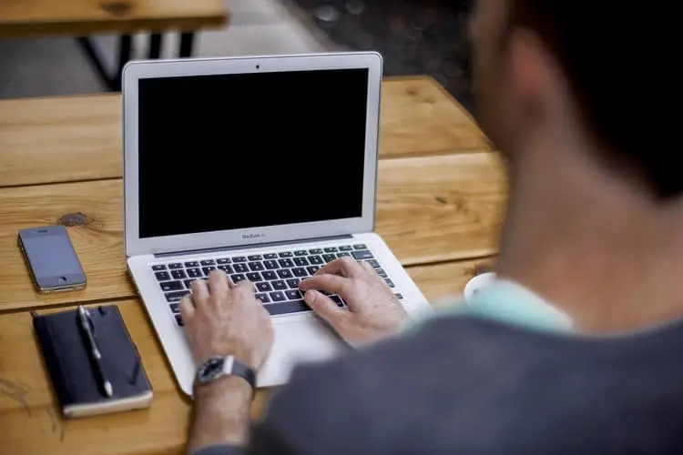 a male blogger working at his laptop