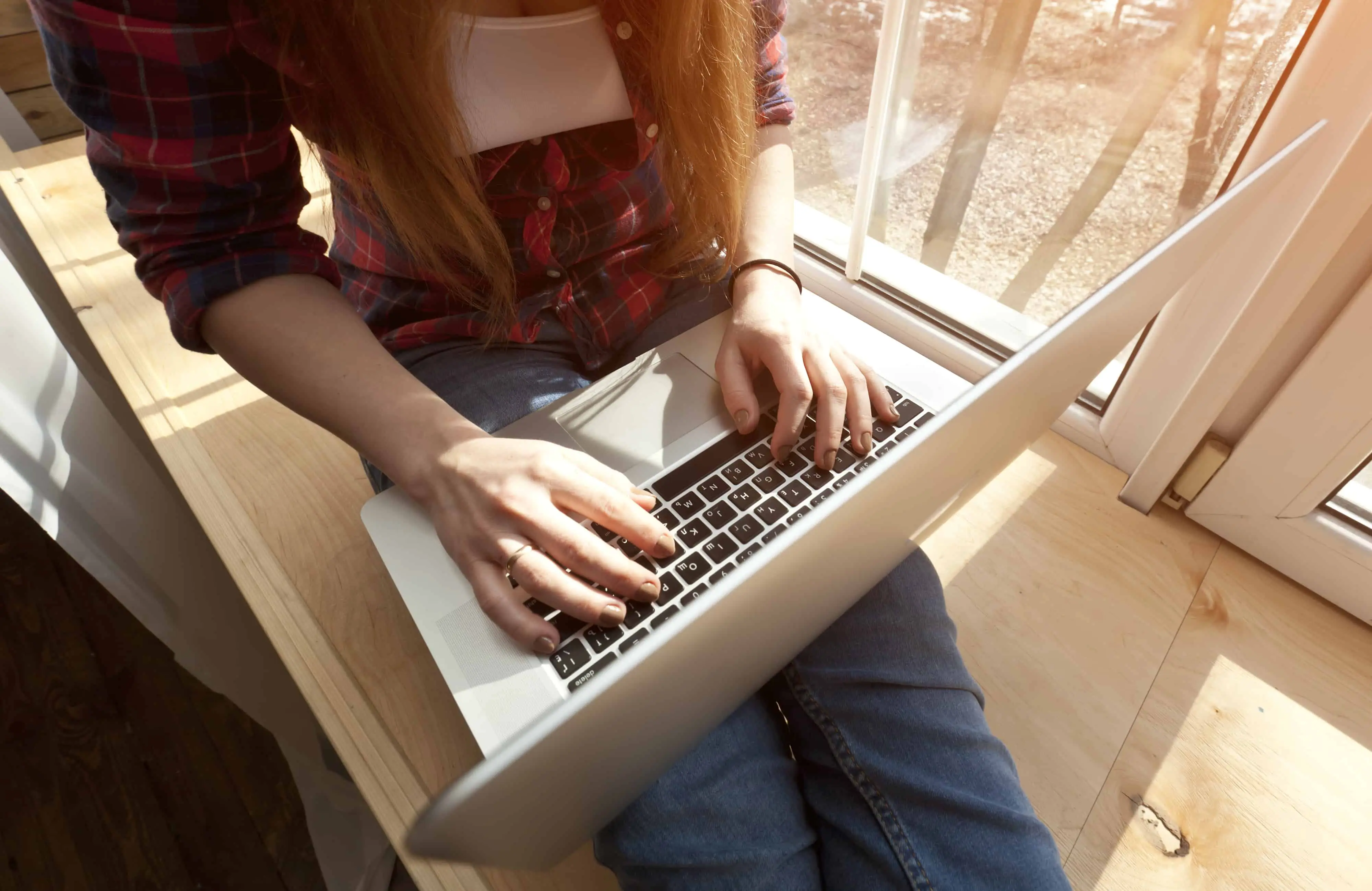 freelancer sitting in the window on her laptop