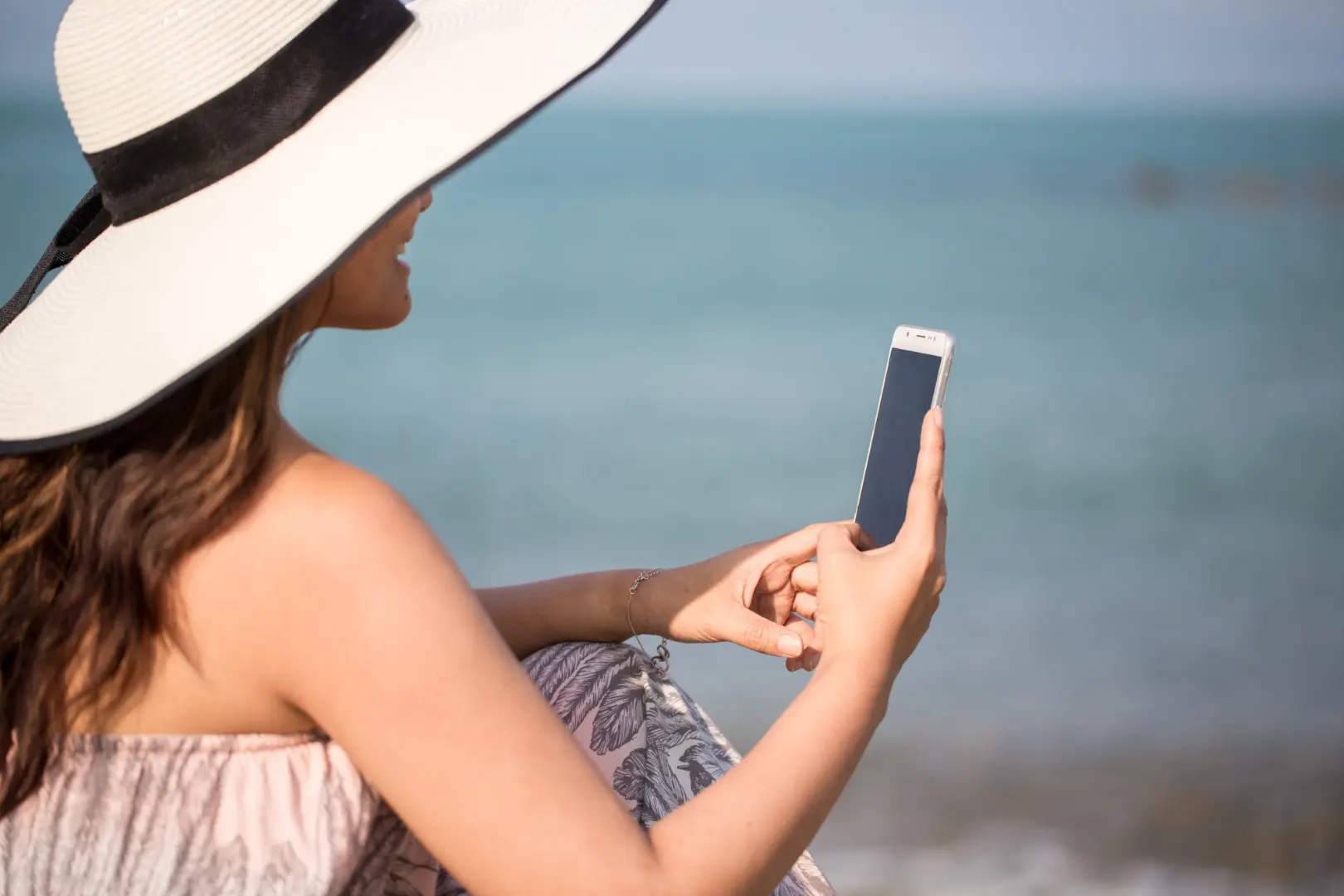 woman on her phone by the sea- you can get paid to use your phone to make extra money without a job!