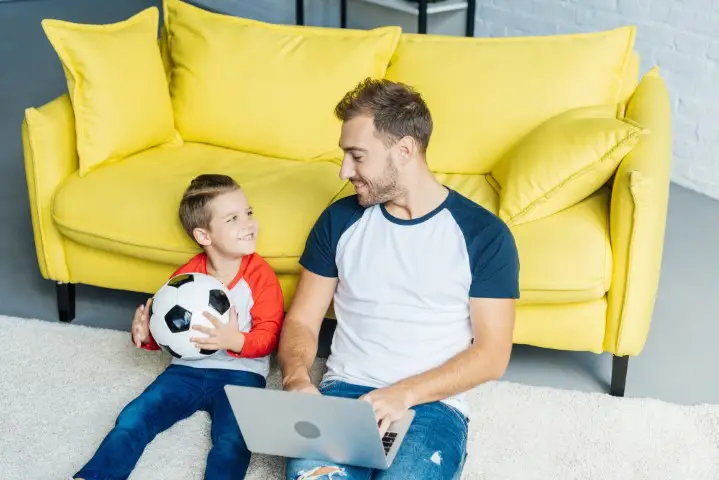 dad with son and football. matched betting is a great side hustle for dads to earn extra money!