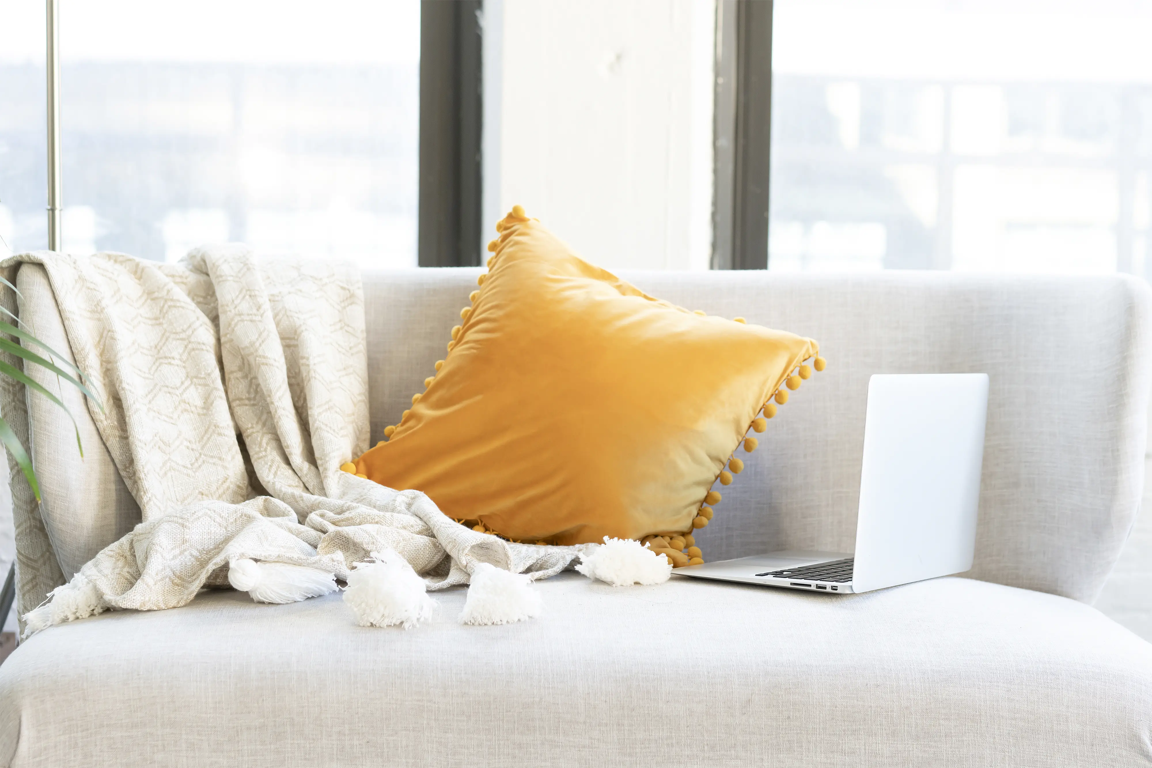 a grey sofa with yellow cushion - this could be your office if you get an online job from home!